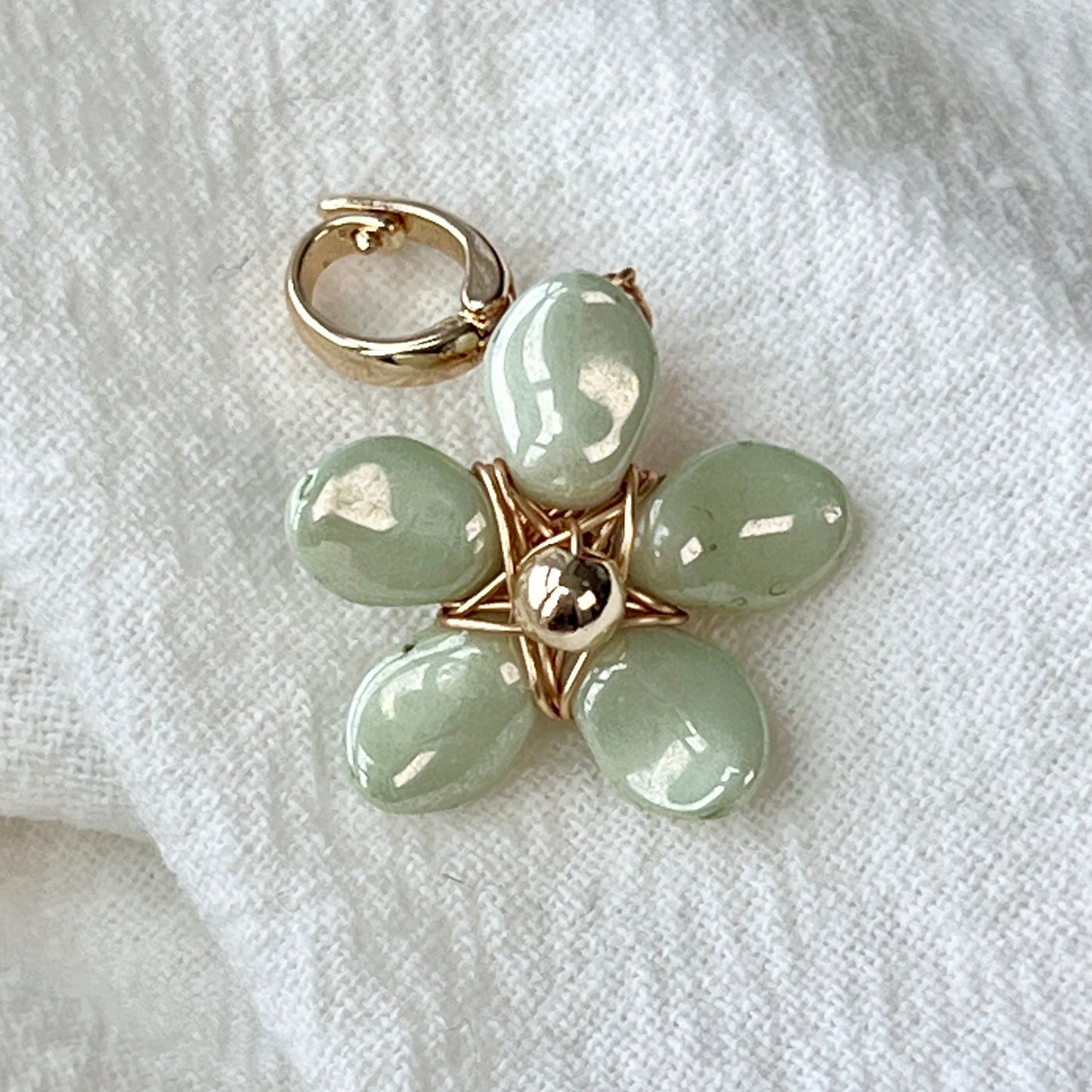 Introducing the Almond 14K Thicker Gold Czech Beads Handcrafted Wire-Wrapped Dreamy Flower Charm Grass Green. This enchanting piece combines the luxurious warmth of 14K thicker gold with the vibrant colors of Czech beads, meticulously hand-wrapped into a delicate floral design. The charm captures a sense of whimsy and elegance, inspired by the beauty of nature’s blooms. Enhanced by an aurora effect, it shimmers with light, adding a touch of magic to your jewelry collection. Crafted with care and intention,